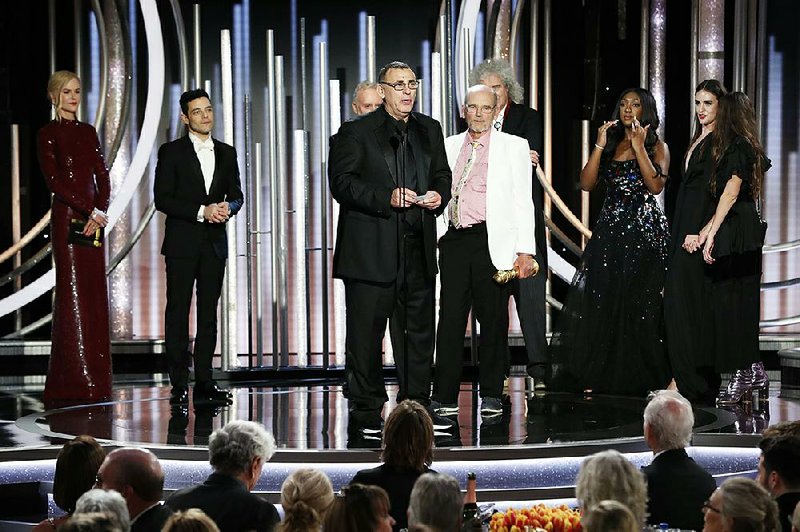 Producer Graham King accepts the award for best motion picture drama for Bohemian Rhapsody at the Golden Globes ceremony Sunday in Beverly Hills, Calif. At left is Rami Malek, who won best actor in a drama for his portrayal of Freddie Mercury.