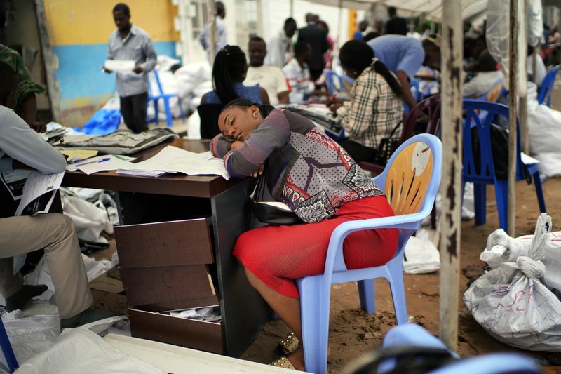 An exhausted Congolese independent electoral commission (CENI) official rests as results are tallied for the presidential election, at a local results compilation center in Kinshasa, Congo, Sunday, Jan. 6, 2019. The winner of the Dec. 30 election will not be made public Sunday as expected, the head of the national electoral commission Corneille Nangaa told The Associated Press. The electoral commission will confirm the delay later Sunday. (AP Photo/Jerome Delay)