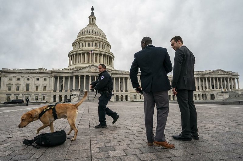A police officer and dog do a routine security check Monday at the nation’s Capitol as the partial government shutdown continues in its third week with President Donald Trump standing firm on his border wall funding demands. 