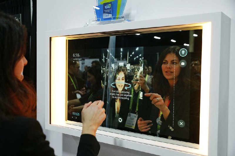 A woman demonstrates the Artemis smart mirror Sunday at the Consumer Electronics Show 2019 in Las Vegas. The mirror has video capture, virtual try-ons, facial and object recognition, and can give the user video instruction on specific makeup products, among other things. 