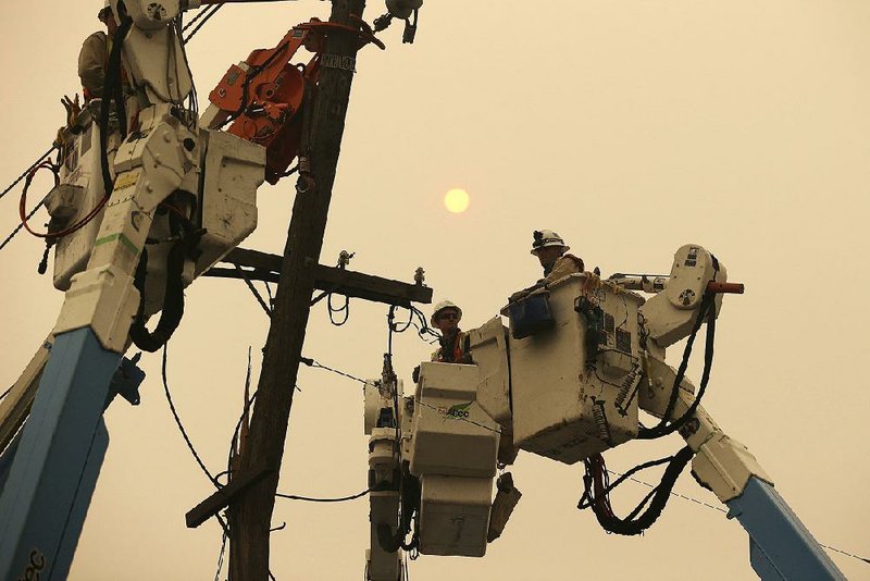 Pacific Gas & Electric crews work to restore power lines in November in Paradise, Calif. California’s largest utility company is reportedly seeking bankruptcy protection in the face of liability damages from a spate of recent wildfires. 