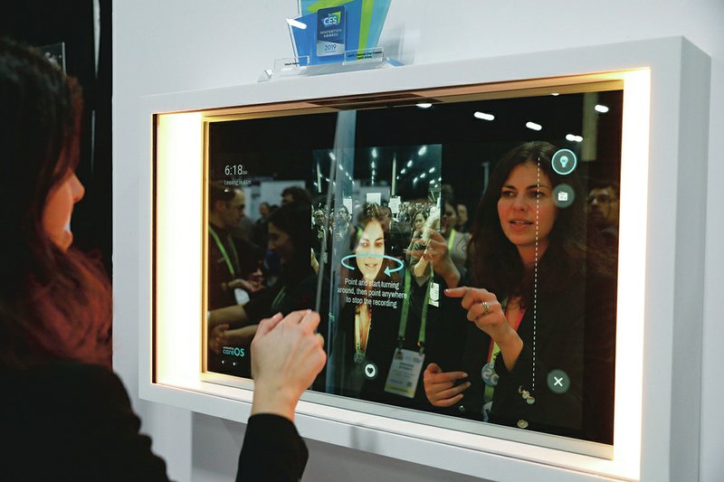 The Associated Press SMART MIRROR: A woman demonstrates the Artemis smart mirror at the CareOS booth during CES Unveiled at CES International, Sunday, in Las Vegas. The interactive mirror has video capture, virtual try-ons, facial and object recognition, and can give the user video instruction on specific makeup products, among other things.