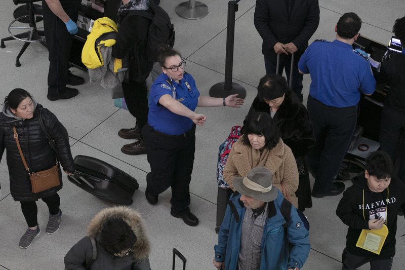 The Associated Press SECURITY DISRUPTION: A TSA agent, center, directs passengers through a security checkpoint, Monday, at New York's John F. Kennedy International Airport. Senate Minority Leader Chuck Schumer, D-N.Y., suggested Sunday that the partial government shutdown is disrupting Transportation Security Administration operations.