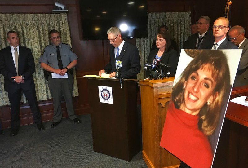 FILE - In this Monday, June 25, 2018 file photo, Lancaster County District Attorney Craig Stedman announces charges in a 1992 cold case killing during a news conference at the Lancaster County Courthouse in Lancaster, Pa. A family photo of the victim, Christy Mirack, is seen at right. A popular DJ in Pennsylvania has been charged in the 1992 killing of Mirack, an elementary school teacher who was sexually assaulted, beaten and strangled in her home as she was getting ready for work. (AP Photo/Mark Scolforo)