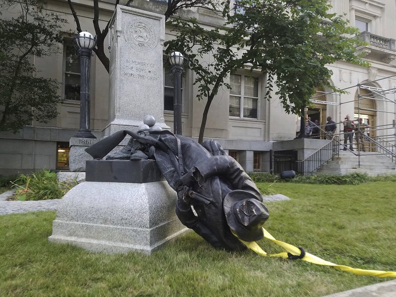 FILE - In this Aug. 14, 2017, file photo, a toppled Confederate statue lies on the ground in Durham, N.C. A North Carolina city will unveil a proposal for the fate of a Confederate monument toppled by protesters in 2017. Durham’s city and county government will hear recommendations Tuesday, Jan. 8, 2019, about what to do with the statue of an anonymous soldier that stood in front of the old county courthouse. (Virginia Bridges/The Herald-Sun via AP, File)

