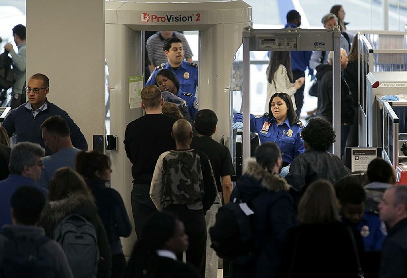 Transportation Security Administration agents help passengers through a security checkpoint Monday at Newark Liberty International Airport in Newark, N.J. 