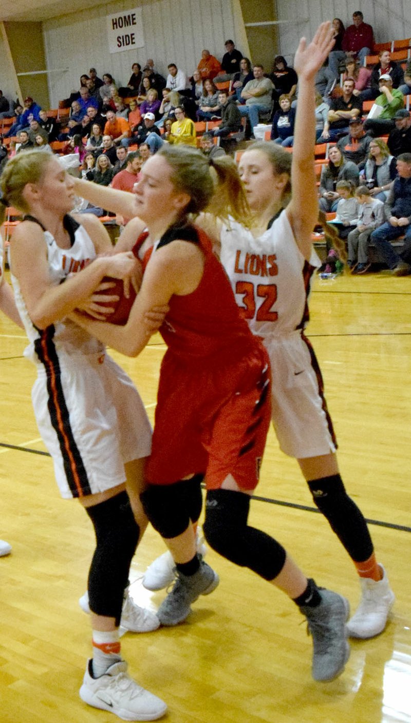 MIKE ECKELS NWA NEWSPAPERS Gravette's Jessica Bookout (left) and Lady Cardinals' Audrey Culpepper (center) fight for control of a loose ball during a 4A-1 Conference basketball contest at the competition gym in Gravette Dec. 21. Farmington won 62-40, then went 2-1 over Christmas break at the Mountain Home tournament.