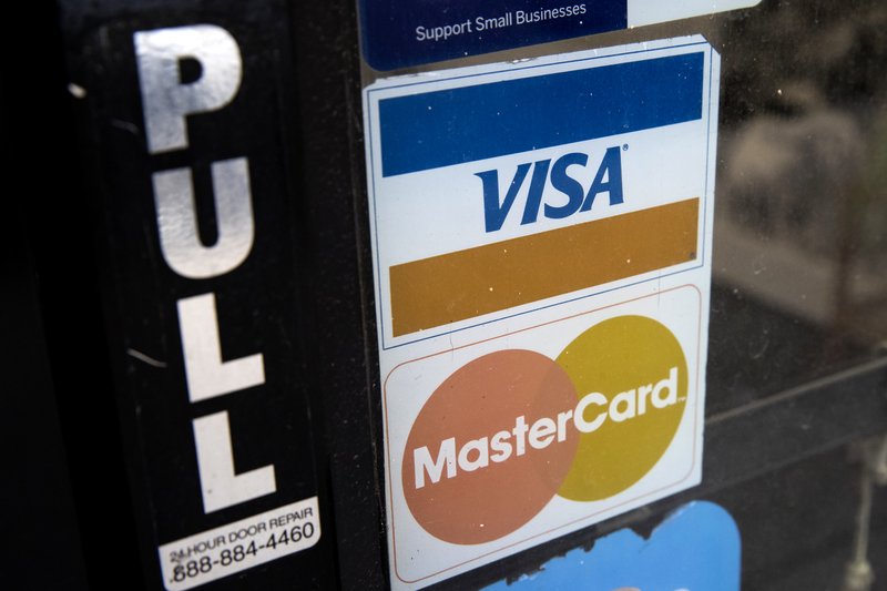 This Nov. 29, 2018, photo shows credit card logos posted on a store's door in Philadelphia. (AP Photo/Matt Rourke)