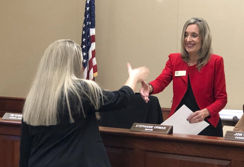NWA Democrat-Gazette/MELISSA GUTE Mayor Stephanie Orman (right) shakes hands Tuesday with Aubrey Patterson after Patterson was sworn in before the Bentonville City Council meeting. Tuesday's meeting was Orman's first as the city's top-elected leader.