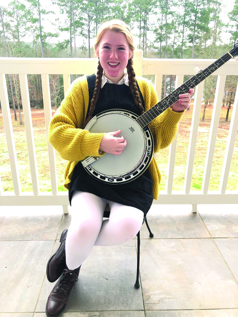 Multi-talented artist Lily Phillips poses with a banjo — one of the many outlets of her creativity. Contributed photo