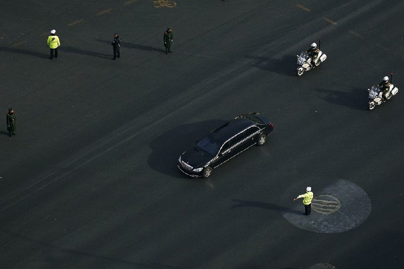 A Mercedes limousine with a golden emblem, similar to one North Korean leader Kim Jong Un has used previously, is escorted by motorcades past Chang’an Avenue on Wednesday in Beijing. 