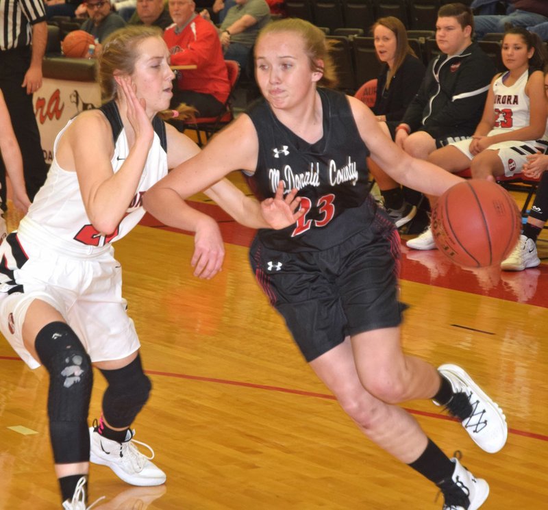 RICK PECK/SPECIAL TO MCDONALD COUNTY PRESS McDonald County's Kristin Penn drives past Aurora's Elizabeth Martin during the Lady Mustangs' 37-32 loss on Jan. 4 at Aurora High School.