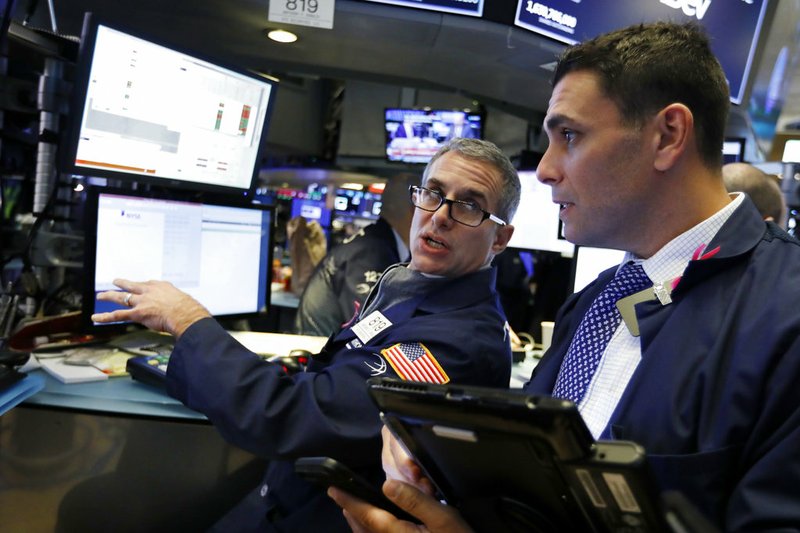 FILE- In this Jan. 3, 2019, file photo specialist Anthony Rinaldi, left, works at his post on the floor of the New York Stock Exchange. The U.S. stock market opens at 9:30 a.m. EST on Thursday, Jan. 10. (AP Photo/Richard Drew, File)