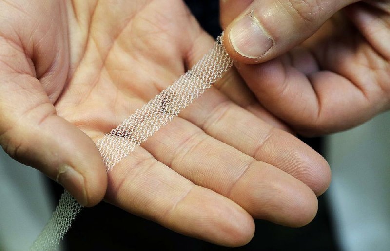 Dr. Jeffrey Clemons, a pelvic reconstructive surgeon in Tacoma, Wash., holds a sample of trans- vaginal mesh used to treat pelvic floor disorders and incontinence in women. 