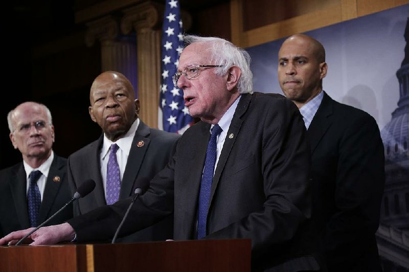 Sen. Bernie Sanders, I-Vt. (center), joined by Rep. Peter Welch, D-Vt. (from left), Rep. Elijah Cummings, D-Md., and Sen. Cory Booker, D-N.J., speaks to reporters as he prepares to introduce new legislation that aims to reduce what Americans pay for prescription drugs, especially brand-name drugs deemed “excessively priced,” during a news conference Thursday on Capitol Hill in Washington. 