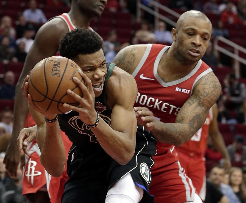 The Associated Press GREEK FREAK: Milwaukee forward Giannis Antetokounmpo, left, protects his rebound from Rockets forward P.J. Tucker, right, Wednesday during the first half of the Bucks' 116-109 win in Houston.