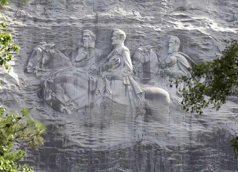 FILE - This June 23, 2015, file photo shows a carving depicting Confederates Stonewall Jackson, Robert E. Lee and Jefferson Davis in Stone Mountain, Ga. A coalition of civil rights groups in Atlanta is using this year's Super Bowl to kick off a renewed "war on the Confederacy," in a fight to remove Confederate monuments around the nation (AP Photo/John Bazemore, File)