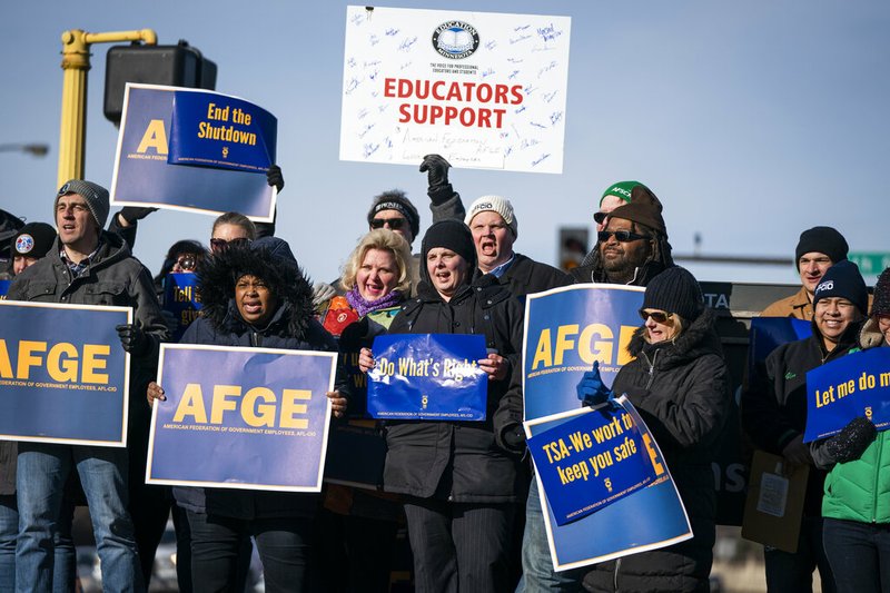 Government workers, American Federation of Government Employees union members and members of supporting local unions, pose for a group photo during the rally to highlight the effect the federal shutdown, Thursday, Jan. 10, 2019, in Minneapolis. (Leila Navidi/Star Tribune via AP)