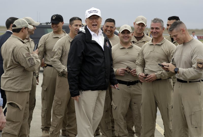 President Donald Trump turns as he talks to U.S. Customs and Border Protection officers at McAllen International Airport as he prepares to leave after a visit to the southern border, Thursday, Jan. 10, 2019, in McAllen, Texas. (AP Photo/ Evan Vucci)

