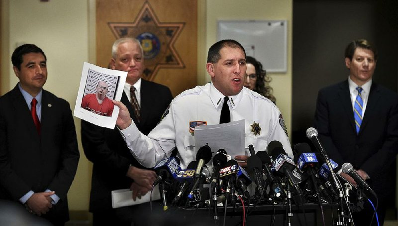Sheriff Chris Fitzgerald of Barron County in Wisconsin holds a booking photo of kidnapping suspect Jake Thomas Patterson during a news conference Friday. Patterson is accused of kidnapping Jayme Closs, 13, who disappeared in October after her parents were killed. Jayme was found alive in Gordon, Wis., about 60 miles from her home. 