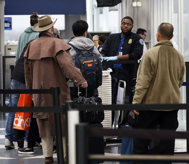 A Transportation Security Administration officer works Friday at a checkpoint at O’Hare airport in Chicago. 