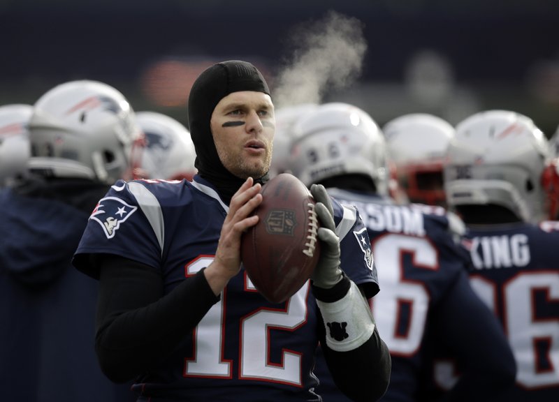 In this Dec. 31, 2017, file photo, New England Patriots quarterback Tom Brady keeps limber on the sideline in the cold weather during the first half of an NFL football game against the New York Jets, in Foxborough, Mass.  (AP Photo/Charles Krupa, File)
