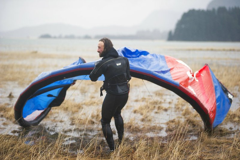 In this Sunday, Dec. 9, 2018, photo, Rob Cadmus drags his kite back to shore after kiteboarding in the Gastineau Channel in Juneau, Alaska. Kiteboarding is making waves with Southeast Alaskans. (Nolin Ainsworth/Juneau Empire via AP)