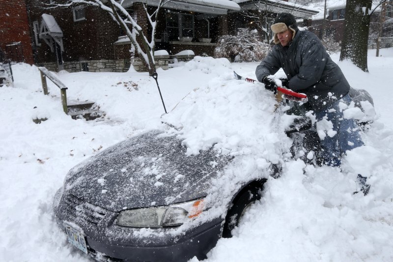 Jeff Clifford digs out his girlfriend's car from a pile of snow on Saturday, Jan. 12, 2019, in St. Louis. Places around St. Louis reported more than a foot of snow by Saturday morning, according to the National Weather Service. (Laurie Skrivan/St. Louis Post-Dispatch via AP)