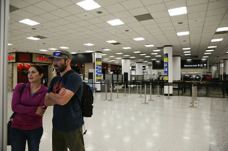 Travelers check a screen Saturday to find their concourse near a closed terminal at Miami International Airport, where some unpaid security screeners have been calling in sick, resulting in staff shortages. Other airports are reporting the same problem. 