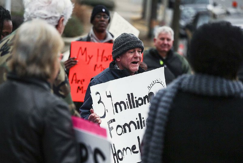 Neil Sealy, an advocate with Arkansas Community Organizations, leads a chant Friday in downtown Little Rock during a protest over the federal government shutdown. Sealy says unfair landlord-tenant laws and inadequately funded code enforcement agencies have led to “deplorable conditions” for some renters. 