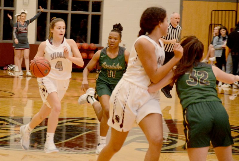 Graham Thomas/Siloam Sunday Siloam Springs senior Chloe Price brings the ball down the floor with Alma's Ariel Towns-Robinson in pursuit Tuesday at Panther Activity Center. Price scored 18 points as the Lady Panthers defeated the Lady Airedales 56-45.