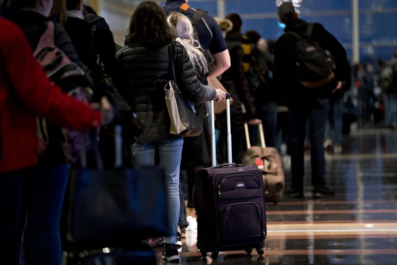 AP/CAROLYN KASTER Travelers check in at American Airlines kiosks at Washington Reagan National Airport in Arlington, Va. 