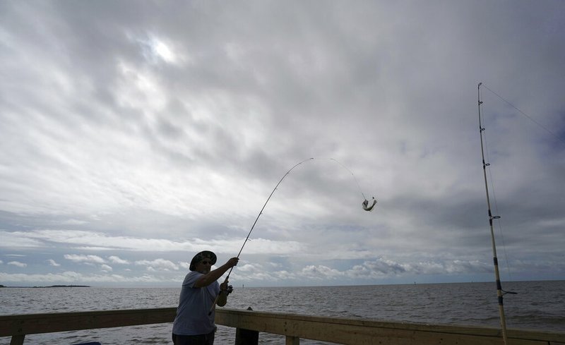 FILE - In this Sept. 5, 2018 file photo, Tim Hitchens, of Gulfprort, Miss., pulls in a fish while fishing from a pier in the Gulf of Mexico, the morning after Tropical Storm Gordon made landfall nearby, in Biloxi, Miss. The rules that govern recreational marine fishing in the U.S. will get an overhaul due to a new law passed by in December. (AP Photo/Gerald Herbert, File)
