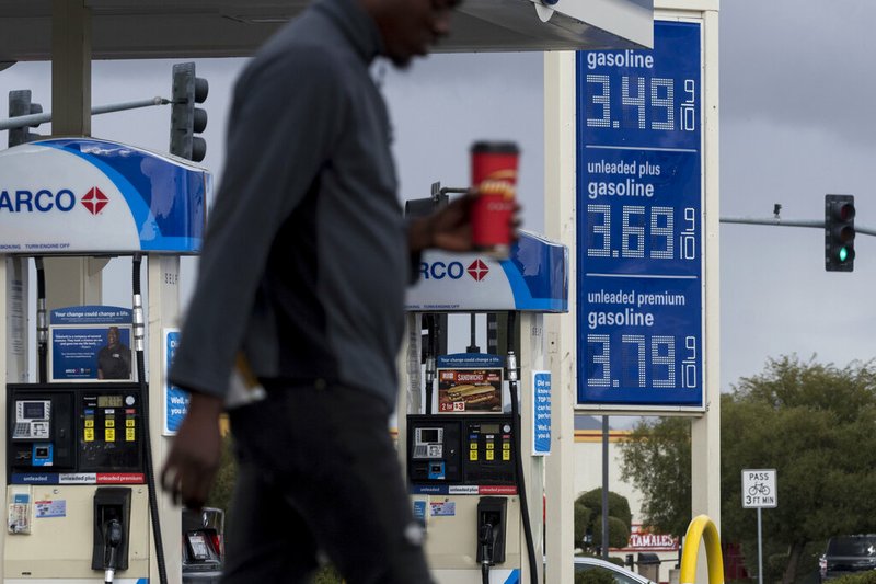 FILE - In this Nov. 29, 2018, file photo, a person walks past a gas station around Victorville, Calif. The average U.S. price of regular-grade gasoline has dropped 12 cents a gallon (3.8 liters) over the past three weeks to $2.31. Industry analyst Trilby Lundberg of the Lundberg Survey says Sunday, Jan. 13, 2019, that falling crude oil costs are the main reason for the decrease at the pump. The average gas price has dropped 66 cents over the past 3 &#189; months. The highest average price in the nation is $3.46 a gallon in the San Francisco Bay Area. The lowest average is $1.80 in Baton Rouge, La. (James Quigg/The Daily Press via AP, File)