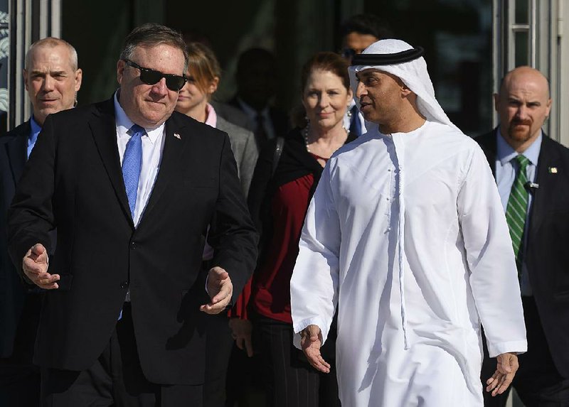 Secretary of State Mike Pompeo (left) and Emirati Ambassador Yousef al-Otaiba confer Sunday during Pompeo’s visit to Abu Dhabi, United Arab Emirates. Pompeo later visited Qatar, saying a boycott of the country by four U.S. allies in the Middle East “has dragged on too long.” 