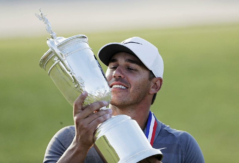 Brooks Koepka holds up the championship trophy after winning the U.S. Open in June in Southampton, N.Y. Koepka said the keys to the victory were 9-irons he hit on the 16th and 17th holes of the final round.