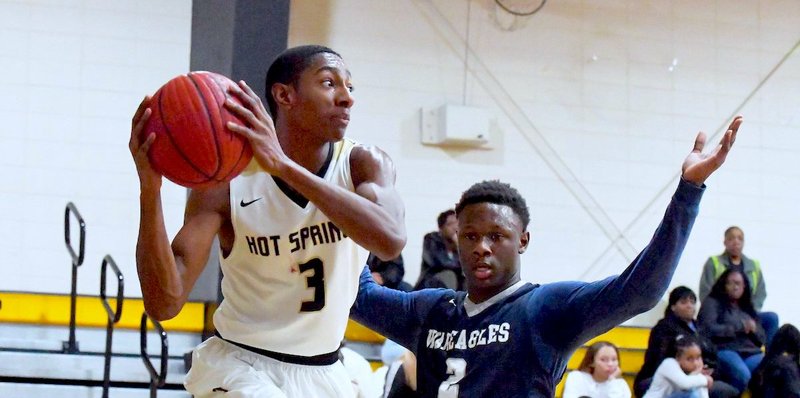 The Sentinel-Record/Grace Brown LOOKING LEFT:Hot Springs junior wing Kaleb Hughley (3) looks to pass as J.A. Fair junior forward Trivez Polite (2) defends on Jan. 4 during a 49-38 home victory at Trojan Fieldhouse.