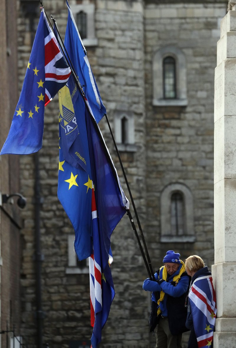 Pro-European demonstrators raise flags to protest, outside parliament in London, Friday, Jan. 11, 2019. Britain's Prime Minister Theresa May is struggling to win support for her Brexit deal in Parliament. Lawmakers are due to vote on the agreement Tuesday, and all signs suggest they will reject it, adding uncertainty to Brexit less than three months before Britain is due to leave the EU on March 29. (AP Photo/Frank Augstein)