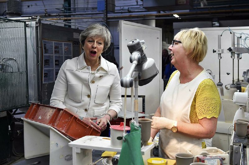 Britain’s Prime Minister Theresa May speaks with Valerie Muni during a visit to the Portmeirion pottery factory in Stoke-on-Trent, England, on Monday.