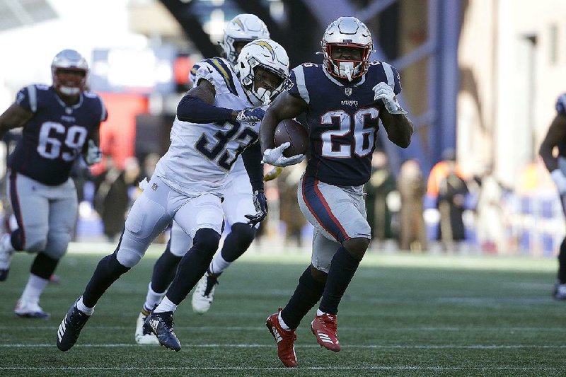 New England Patriots running back Sony Michel runs away from Los Angeles Chargers free safety Derwin James during the first half of Sunday’s AFC divisional playoff game in Foxborough, Mass. Michel ran for 129 yards and scored three touchdowns, the most by a Patriots’ rookie in a playoff game.