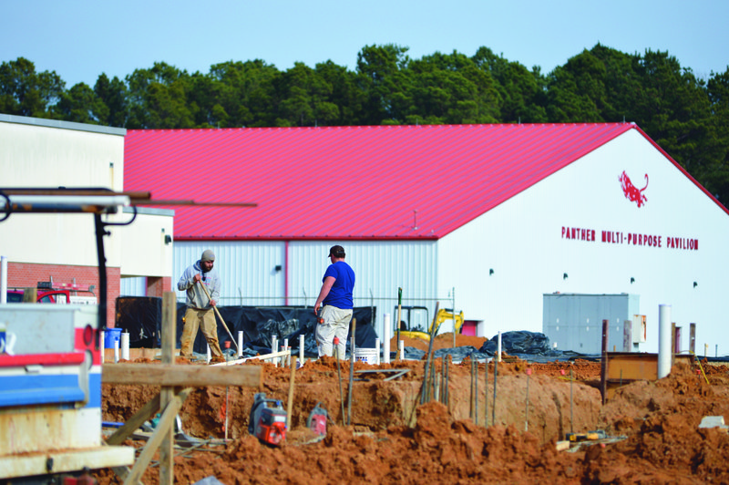  Construction workers Tuesday at the MHS Ninth Grade Academy jobsite prep a patch of ground for concrete pouring. 