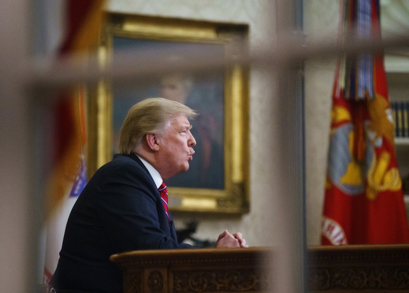 FILE- In this Tuesday, Jan. 8, 2019, file photo seen from a window outside the Oval Office, President Donald Trump gives a prime-time address about border security at the White House in Washington. With the standoff over paying for his long-promised border wall dragging on, the president&#x2019;s Oval Office address and visit to the Texas border over the past week failed to break the logjam and left aides and allies fearful that the president has misjudged Democratic resolve and is running out of negotiating options. (AP Photo/Carolyn Kaster, File)