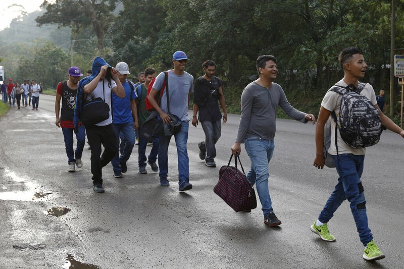 U.S.-bound migrants walk along the roadside as they leave Cofradia, Honduras, early Tuesday, Jan. 15, 2019. Yet another caravan of Central American migrants set out overnight from Honduras, seeking to reach the U.S. border following the same route followed by thousands on at least three caravans last year. (AP Photo/Delmer Martinez)