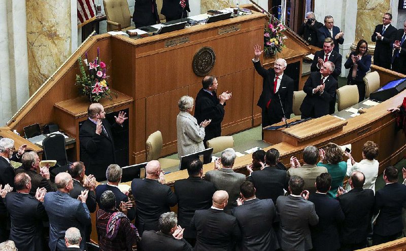 Gov. Asa Hutchinson acknowledges the applause Tuesday after his swearing-in ceremony in the House chamber. “Today, we have a budget that allows for tax cuts while investing in the future,” Hutchinson said in his State of the State address that followed. “We have demonstrated that we can do it, and we will do it again.” 