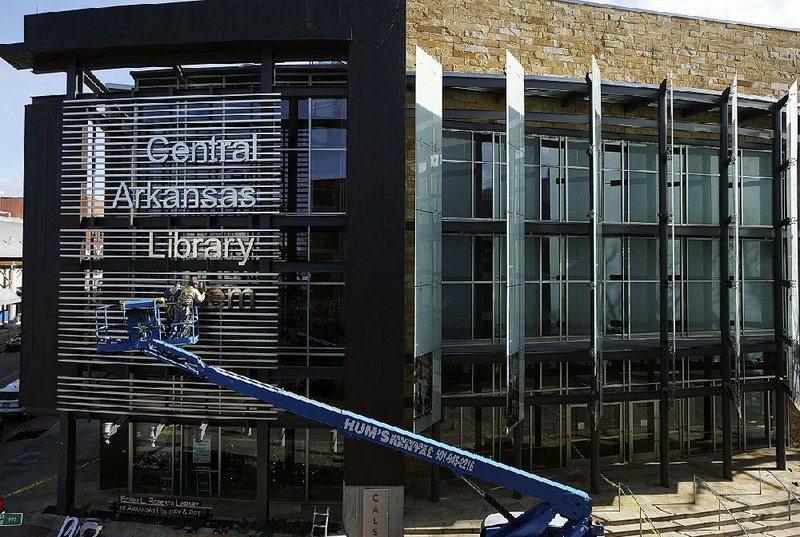 Arkansas Democrat-Gazette/MITCHELL PE MASILUN -- 1/15/2019 --
Workers put the finishing touches on a new sign on the facade of the Central Arkansas Library's Roberts Library & Butler Center for Arkansas Studies building Tuesday, Jan 15, 2018 in Little Rock.