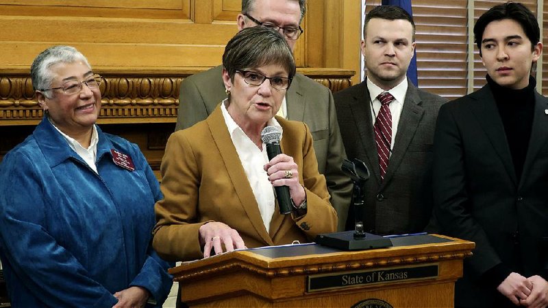Kansas Gov. Laura Kelly on Tuesday reviews her new executive order on hiring gay and transgender people at the Statehouse in Topeka. At left is state Rep. Susan Ruiz, D-Shawnee, Kansas’ first openly lesbian state legislator. 