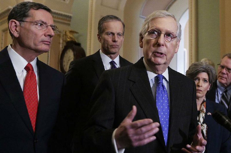 Senate Majority Leader Mitch McConnell, R-Ky., speaks to reporters Tuesday after a policy meeting on Capitol Hill in Washington. From left are Sen. John Barrasso, R-Wyo., and Majority Whip John Thune, R-S.D. 