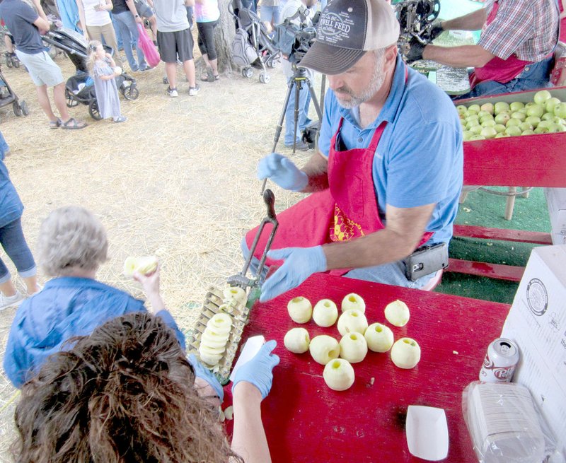 FILE PHOTO The Apple Festival Committee gave out around 100 bushels of fresh apple slices during the 43rd Arkansas Apple Festival in October, a the event over the weekend. Jonathan Brewer is taking his turn to slice apples.