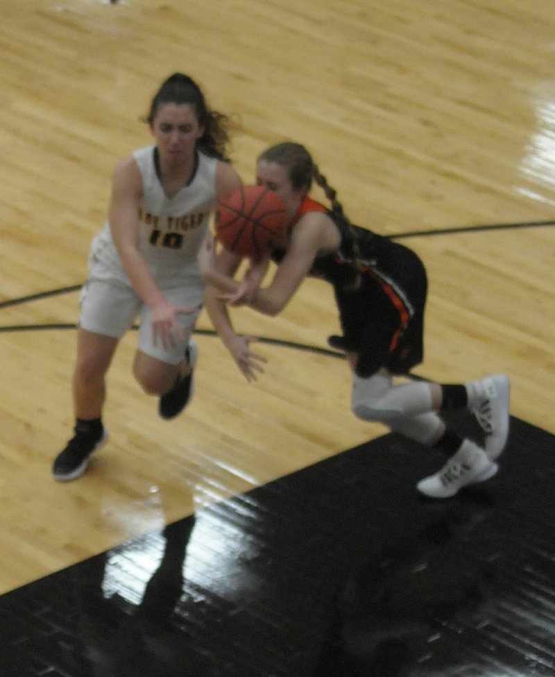 MARK HUMPHREY ENTERPRISE-LEADER/Gravette sophomore Kaylan Chilton jumps a pass intended for Prairie Grove senior Lexie Madewell. Their collision resulted in an all-out battle for possession of the basketball. Gravette defeated Prairie Grove in 4A-1 Conference girls basketball action, 48-40, on Tuesday, Jan. 8, 2019, at Tiger Arena.