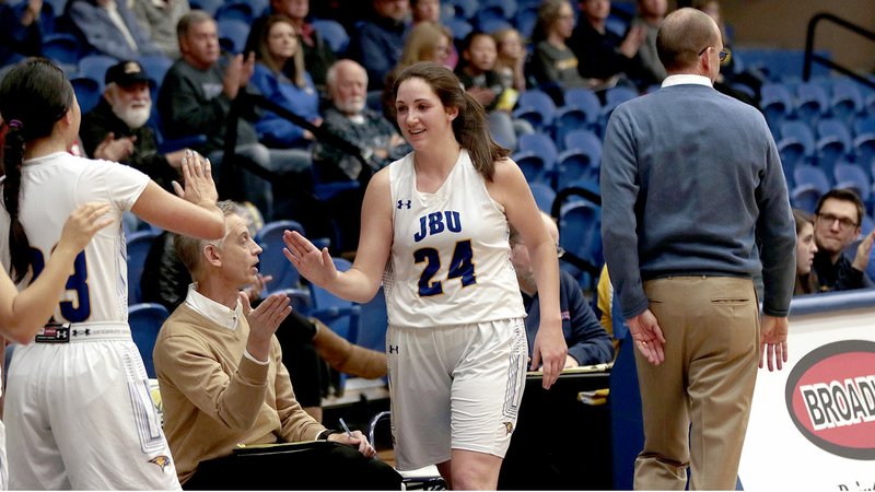 Photo courtesy of John Brown University John Brown senior Baily Cameron is congratulated by teammates after coming out of Saturday's game against Mid-America Christian. Cameron became the JBU women's basketball program's all-time leading scorer on Saturday.